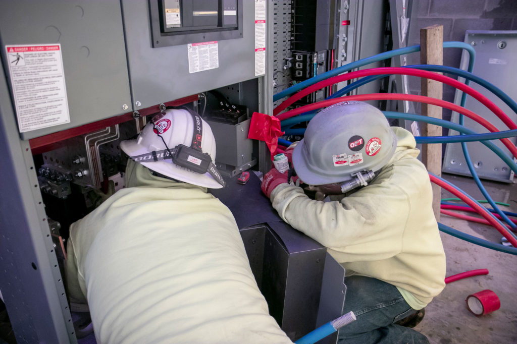Converse Electric technicians working in large electric box