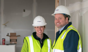 Laura Converse-Haines and Chris Converse smiling in hard hats
