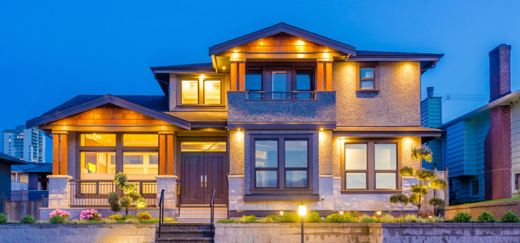 View of front of house at dusk with outdoor lights on