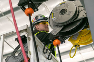 Converse Electric technician working on a lift