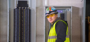 Converse Electric technician standing in front of electric panel