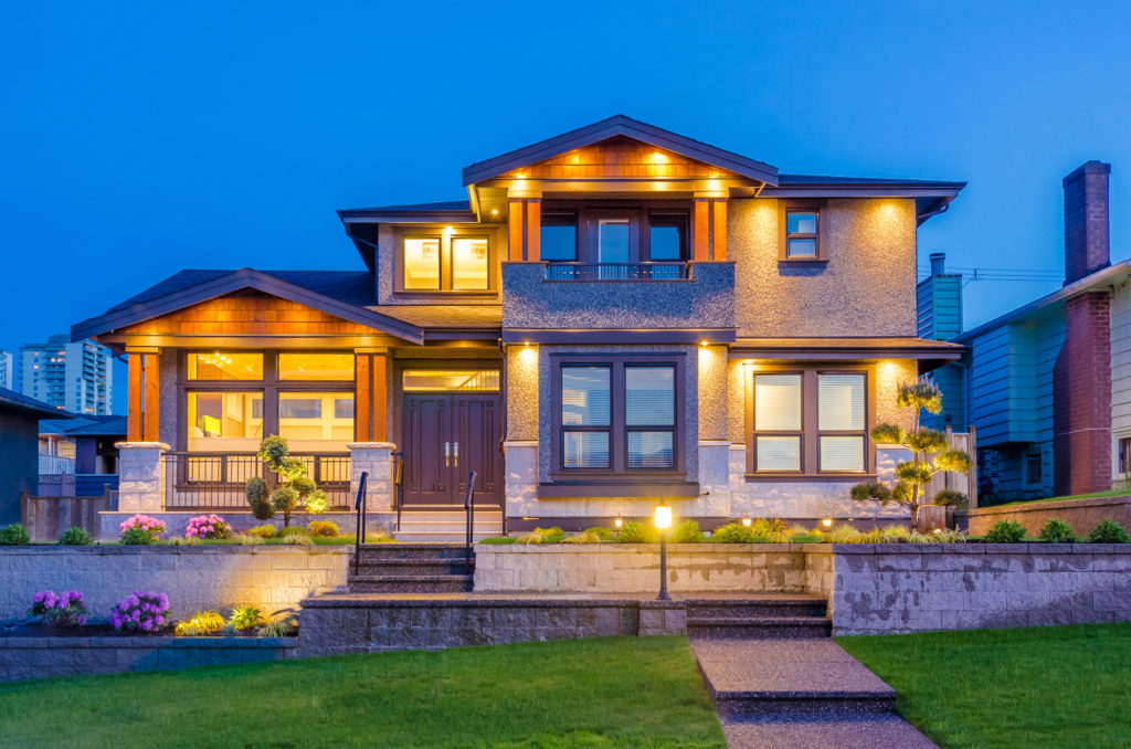 View of front of house at dusk with outdoor lights on