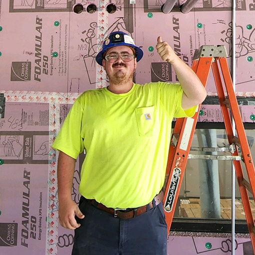 Converse Electric technician smiling on the job site giving a thumbs up