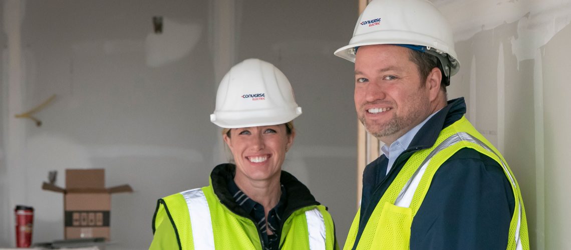 Laura Converse-Haines and Chris Converse smiling in hard hats
