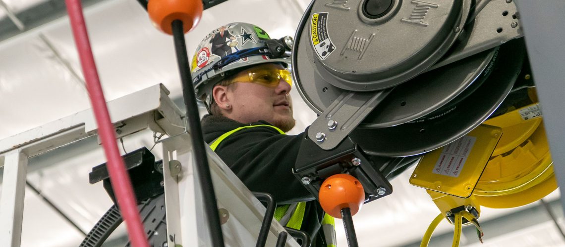 Converse Electric technician working on a lift