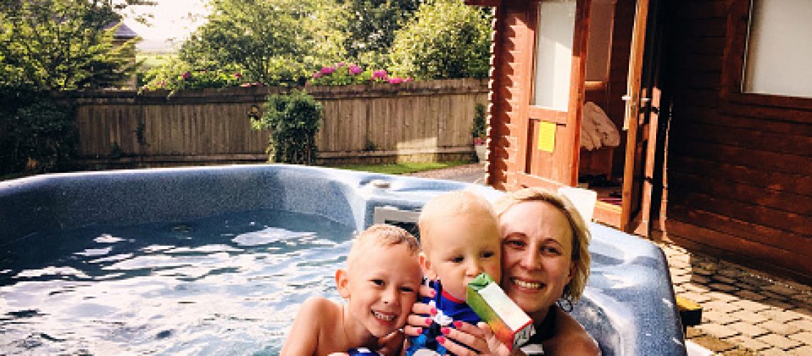 Mom with young kids in outside hot tub